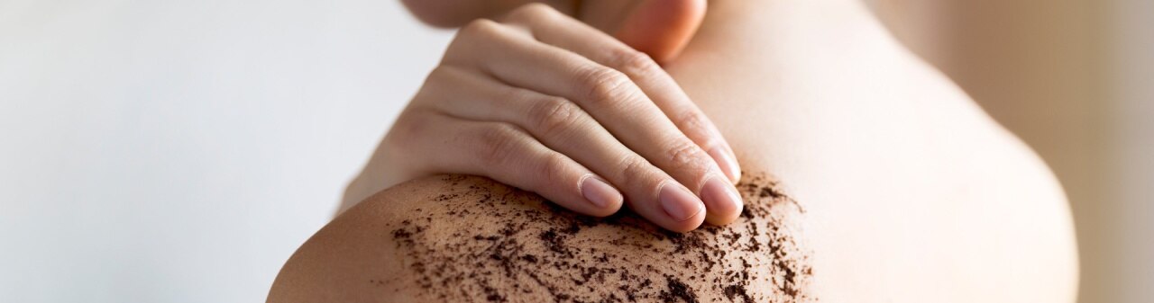 Mujer exfoliando su piel con exfoliante natural con café